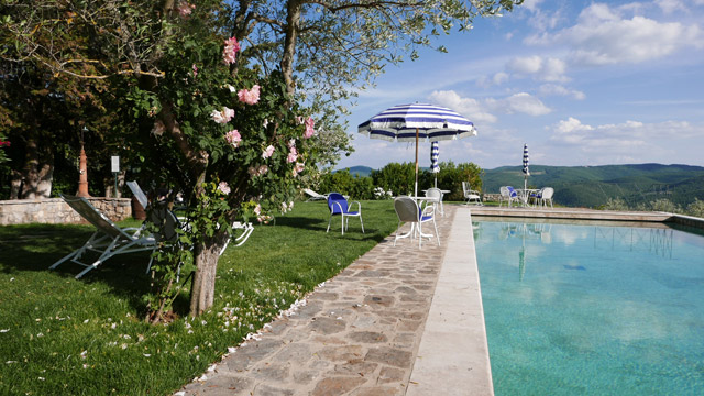 Infinity pool with sun umbrellas at Villa le Barone Tuscany